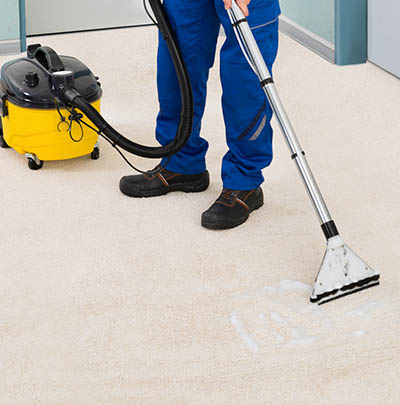 Male Cleaner Vacuuming Floor