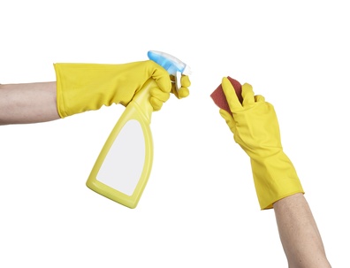 Cleaning surface in bright yellow gloves with sponge and cleanin